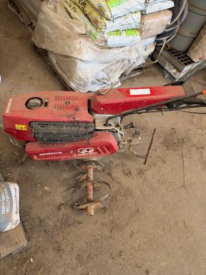 une machine rouge posée par terre à côté d'un tas de sacs