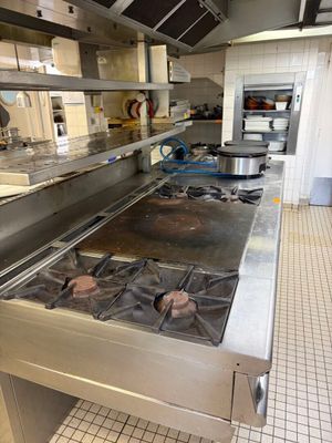 une grande cuisine équipée d'une cuisinière et de nombreux plans de travail