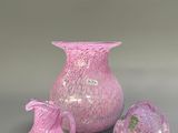 three pieces of pink glass sitting on a table next to each other