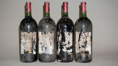 quatre bouteilles de vin sont alignées sur une table
