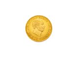 gros plan d'une pièce d'or sur une surface blanche