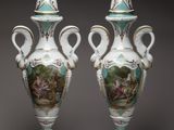 pair of vases with painted scenes on them on a gray background