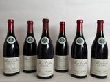 six bottles of wine are lined up in a row on a table