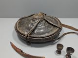 un petit bol en métal muni d'une poignée en bois et une paire de cuillères en bois