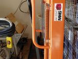 a fork lifter that is sitting in front of a stack of pallets