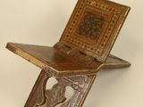a small wooden chair that has a wooden seat on top of it