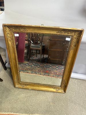 un miroir posé sur le sol à côté d'une chaise