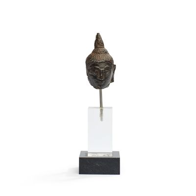 une image représentant une statue représentant une tête de Bouddha posée sur un socle transparent