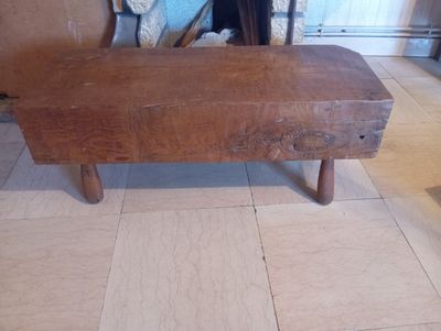 un banc en bois posé sur un sol carrelé, devant une cheminée
