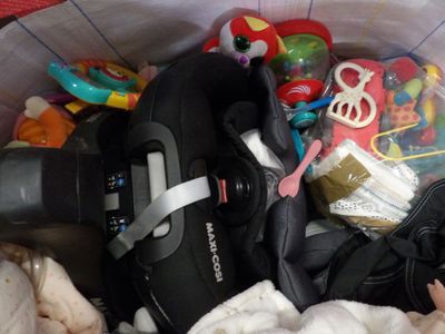 a baby in a stroller filled with toys