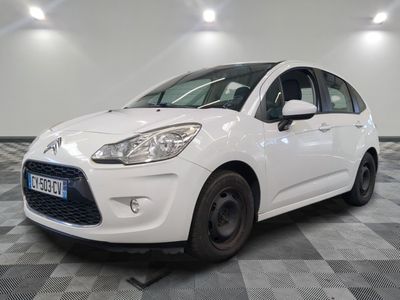 la voiture blanche est garée sur un sol en damier dans le garage