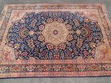 an antique persian rug with a medallion design on a blue ground