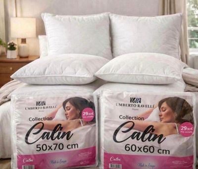 deux oreillers posés sur un lit dans une chambre, près d'une fenêtre