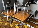 des tables et des chaises dans une pièce au sol carrelé et dotée d'une fenêtre
