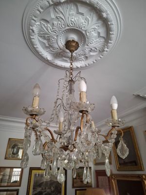 a chandelier in a room with pictures on the wall