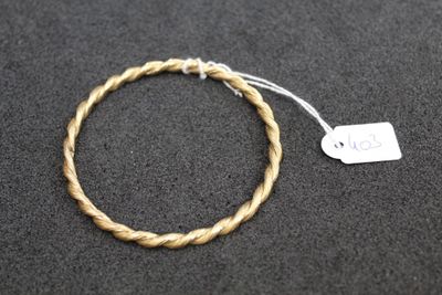 a close up of a rope bracelet with a tag on it