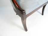 une chaise dont l'assise est rembourrée et recouverte de tissu bleu