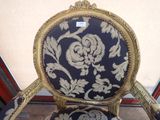 a chair that has a blue and gold upholstered seat