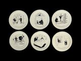 quatre assiettes blanches ornées d'illustrations en noir et blanc sur fond noir