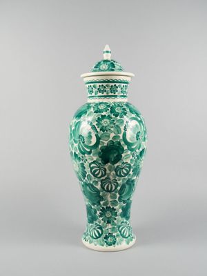 un vase vert et blanc posé sur une table