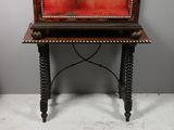 an old wooden writing desk with a red and black painting on the top