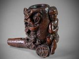 une pipe ornée d'un dragon, posée sur une table