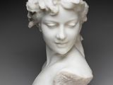 a close up of a statue of a woman with flowers on her head