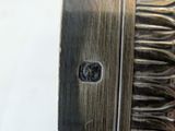 a close up of a silver plate with a comb on it
