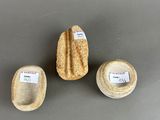 three pieces of stone with labels on them sitting on top of a table