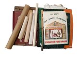 une photo montrant un livre et quelques rouleaux de papier posés sur une table