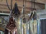 five wine glasses hanging from the ceiling of a room