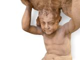 une statue représentant un homme tenant un grand bol sur la tête