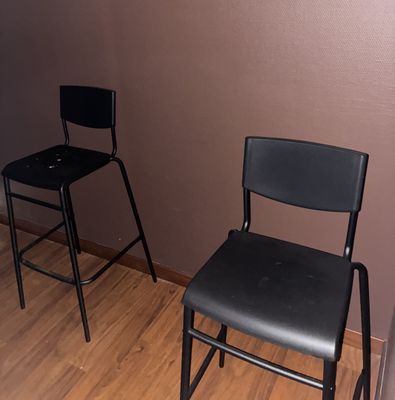 une chaise noire et un tabouret noir dans une pièce
