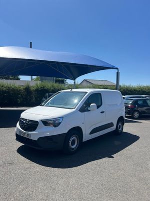 une camionnette blanche garée sur un parking sous un auvent
