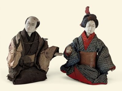 paire de figurines asiatiques représentant un homme et une femme accompagnés d'un chien