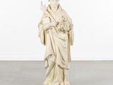 a white statue of a woman holding a bouquet of flowers