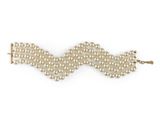 a close up of a pearl bracelet on a white background