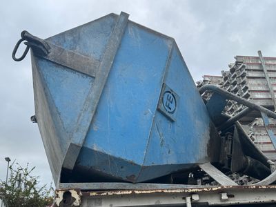 a blue dump truck with a large blue bin on the back of it