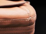 close up of a brown leather bag with a zipper on it