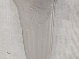 a glass vase on the wall next to a white wall