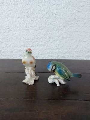 deux figurines d'oiseaux posées sur une table en bois