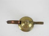 an old brass plate with a brown leather handle on a white surface