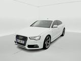 une Audi blanche garée dans une pièce blanche aux murs blancs