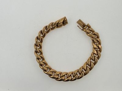 a close up of a gold bracelet on a white surface