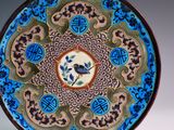 a blue and brown plate with a bird on it