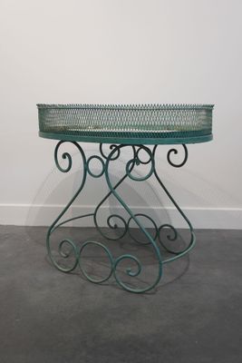 une photo d'une table avec un plateau en verre posée sur un sol en béton
