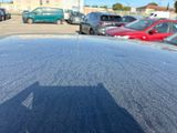 a shadow of a person standing on the hood of a car