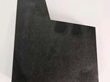a close up of a piece of black paper on a white surface