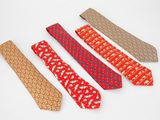 quatre cravates de couleurs différentes sont alignées sur une surface blanche