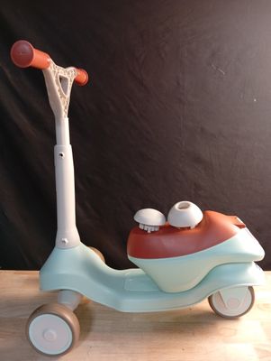 a toy scooter with two wheels on a wooden table